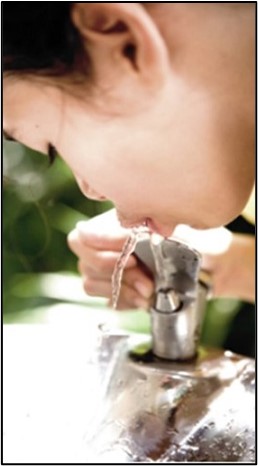 young child drinking from fountain