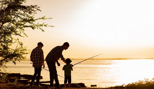 People fishing by a lake at twilight.