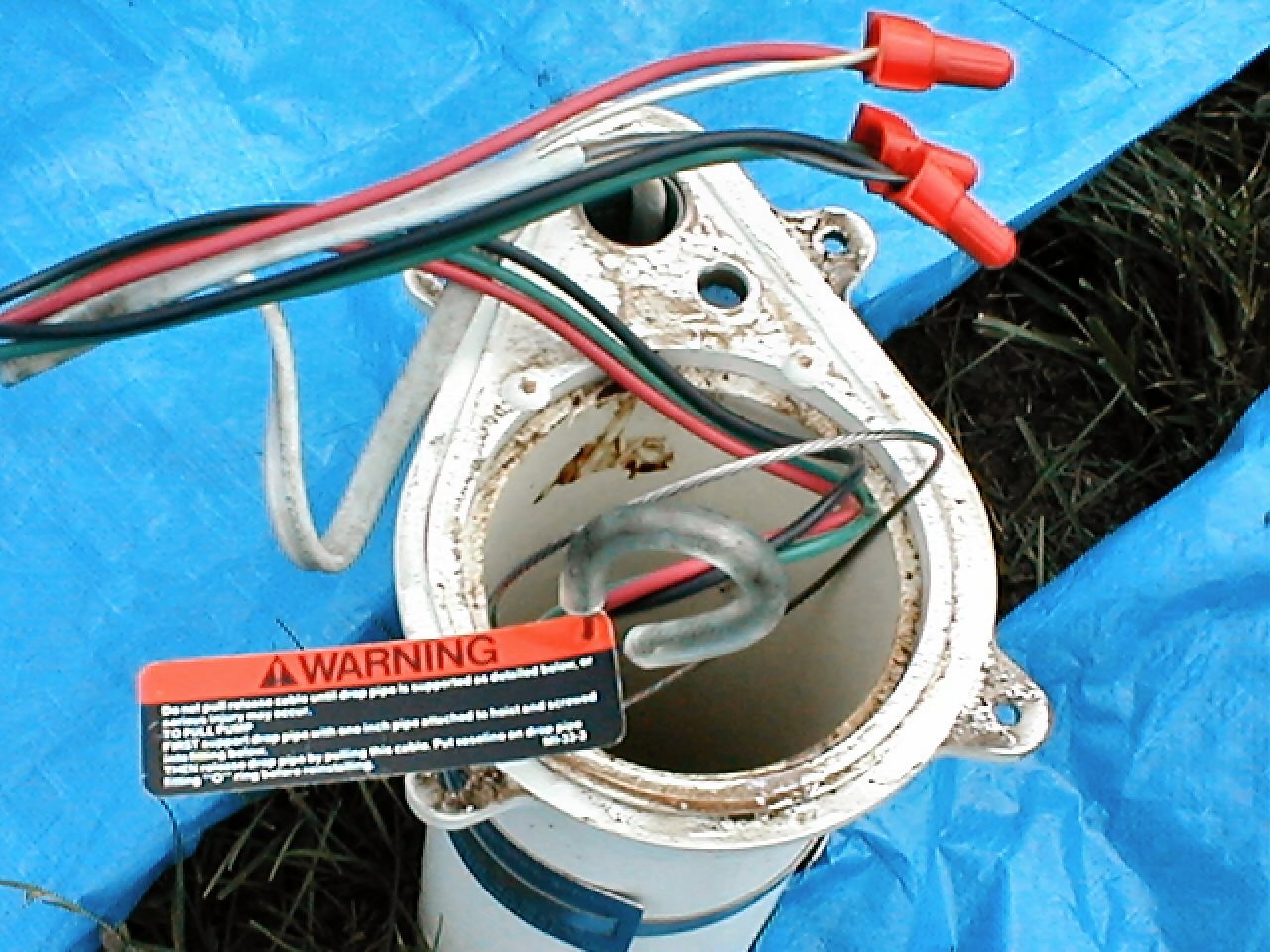 Wires with connector caps showing outside well casing.