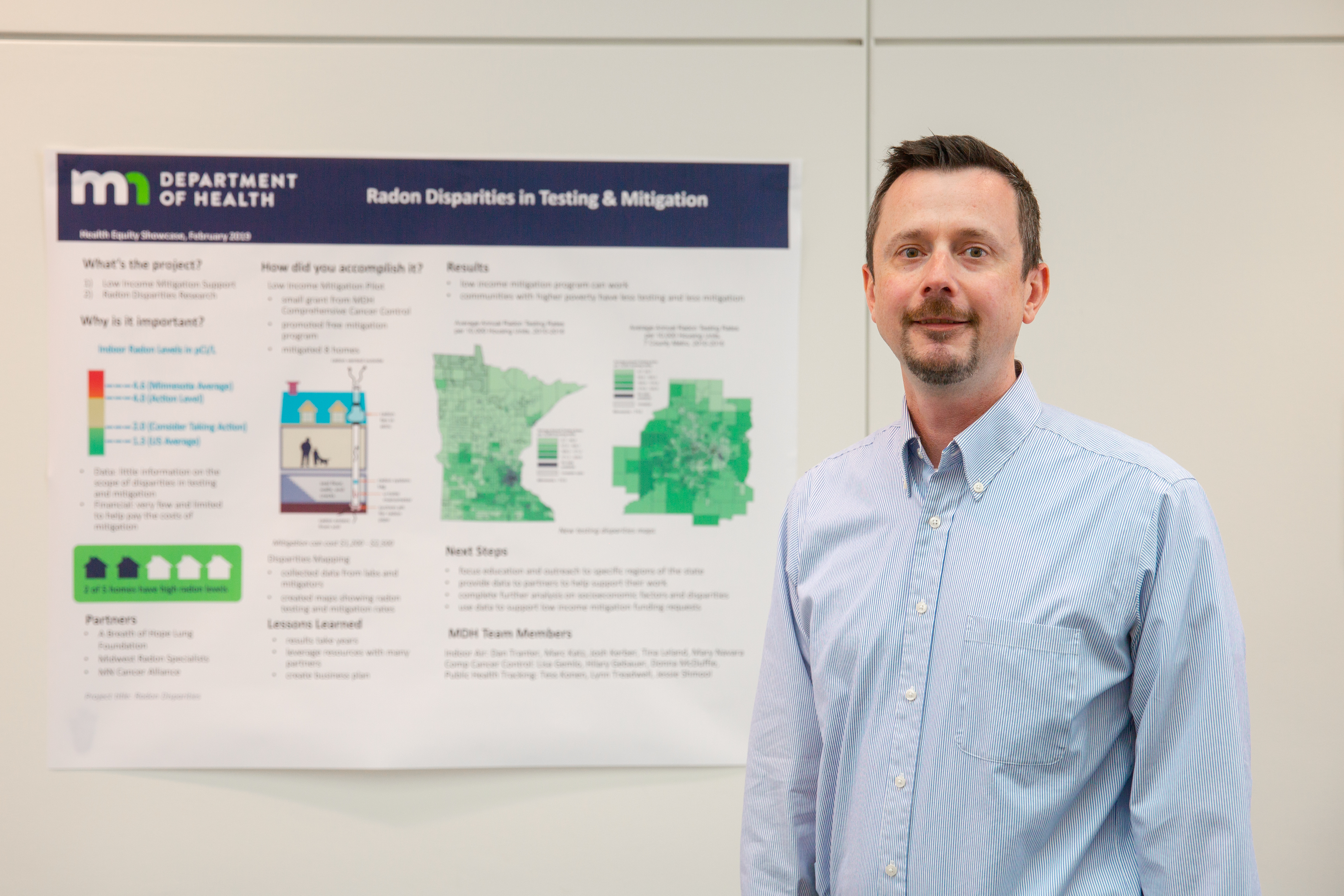 Photo of project lead with poster - radon disparities project