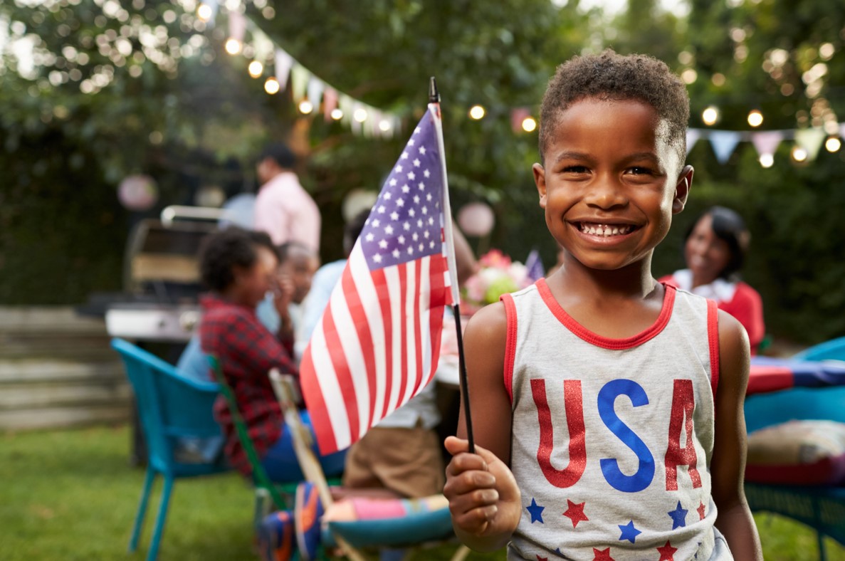 Young black boy holding american flag.