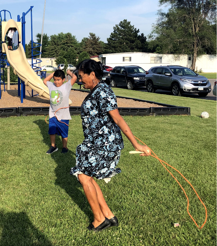 Older person skips rope while a child looks on