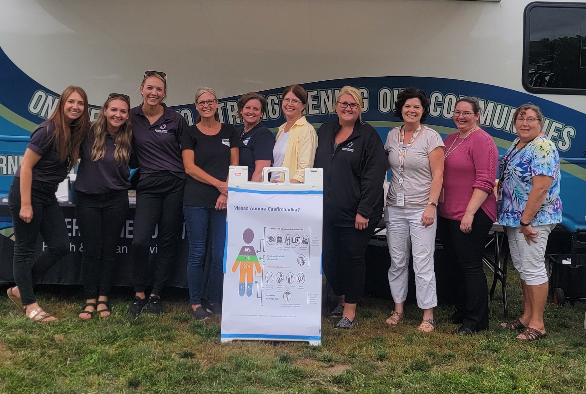 Photo of Health Festival in St Cloud, featuring 10 CMA Staff in front of the Sherburne County Wellness Bus.