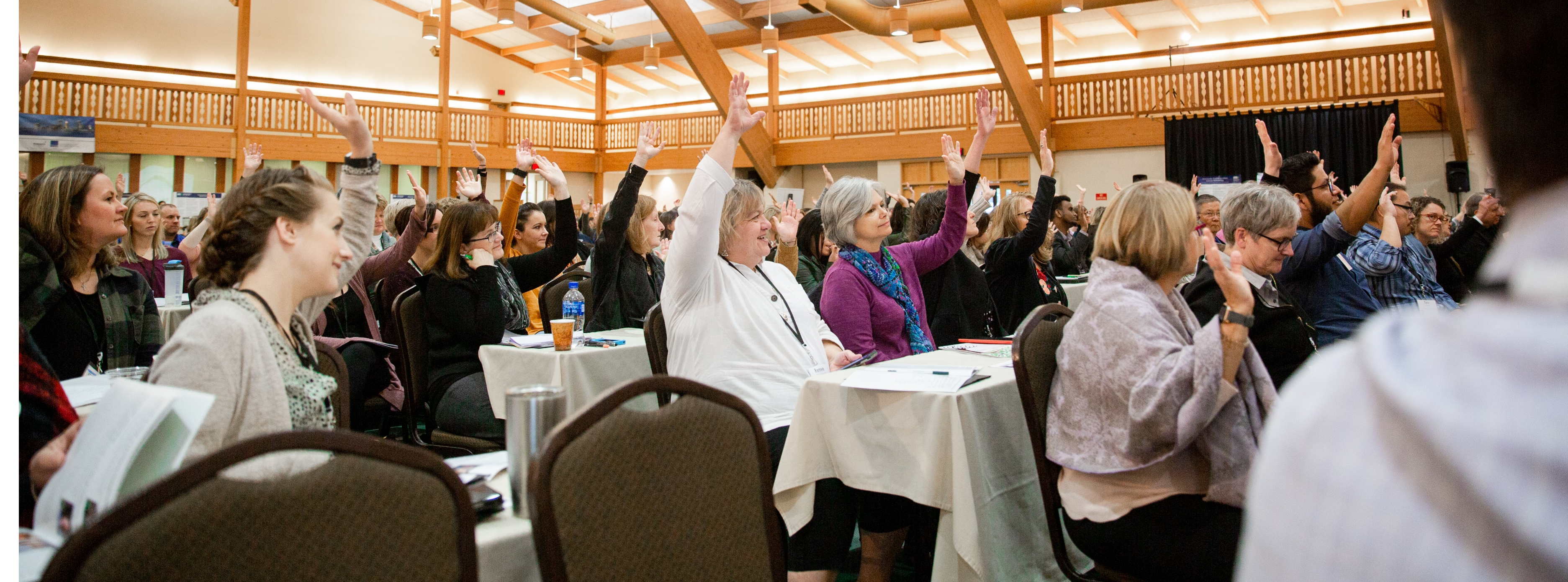 Attendees raising hands at a past MDH event