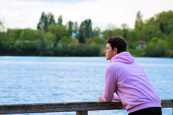 Male teen overlooking lake.