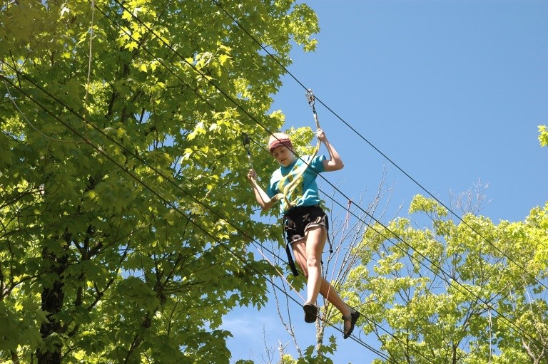 image: Maci Fox takes a turn on the ropes challenge course.