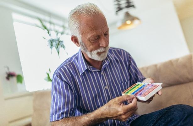 Man looking at pill organizer