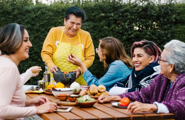 Group of people at a picnic table with food