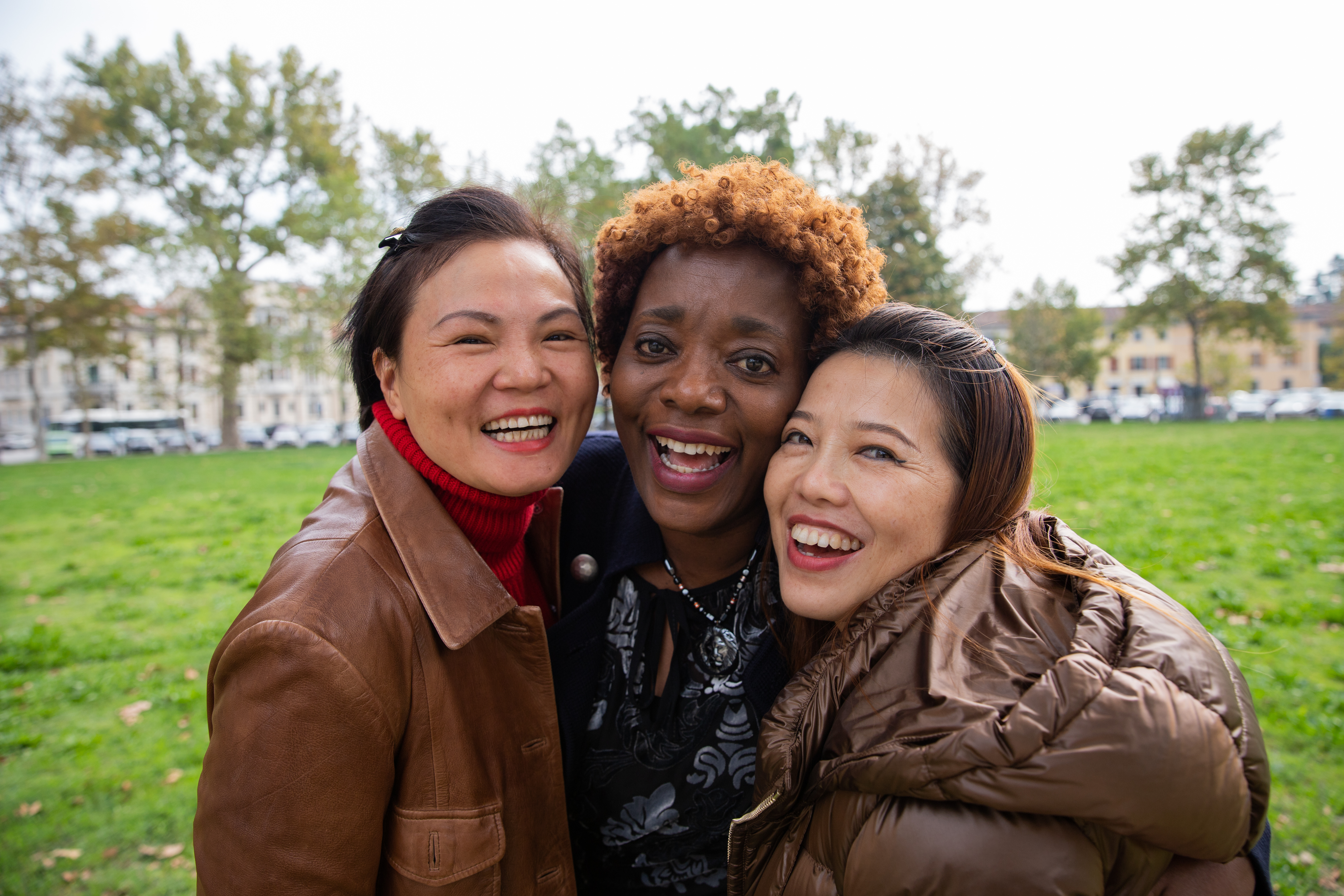 three women smiling in a park