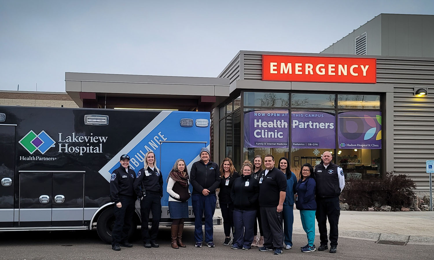 healthcare workers standing in front of an ambulance