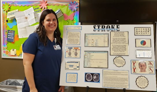 woman in scrubs standing next to a Stroke poster