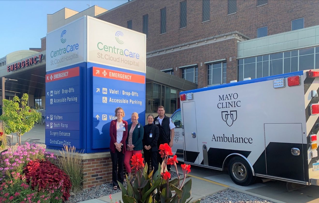 healthcare workers standing next to an ambulance