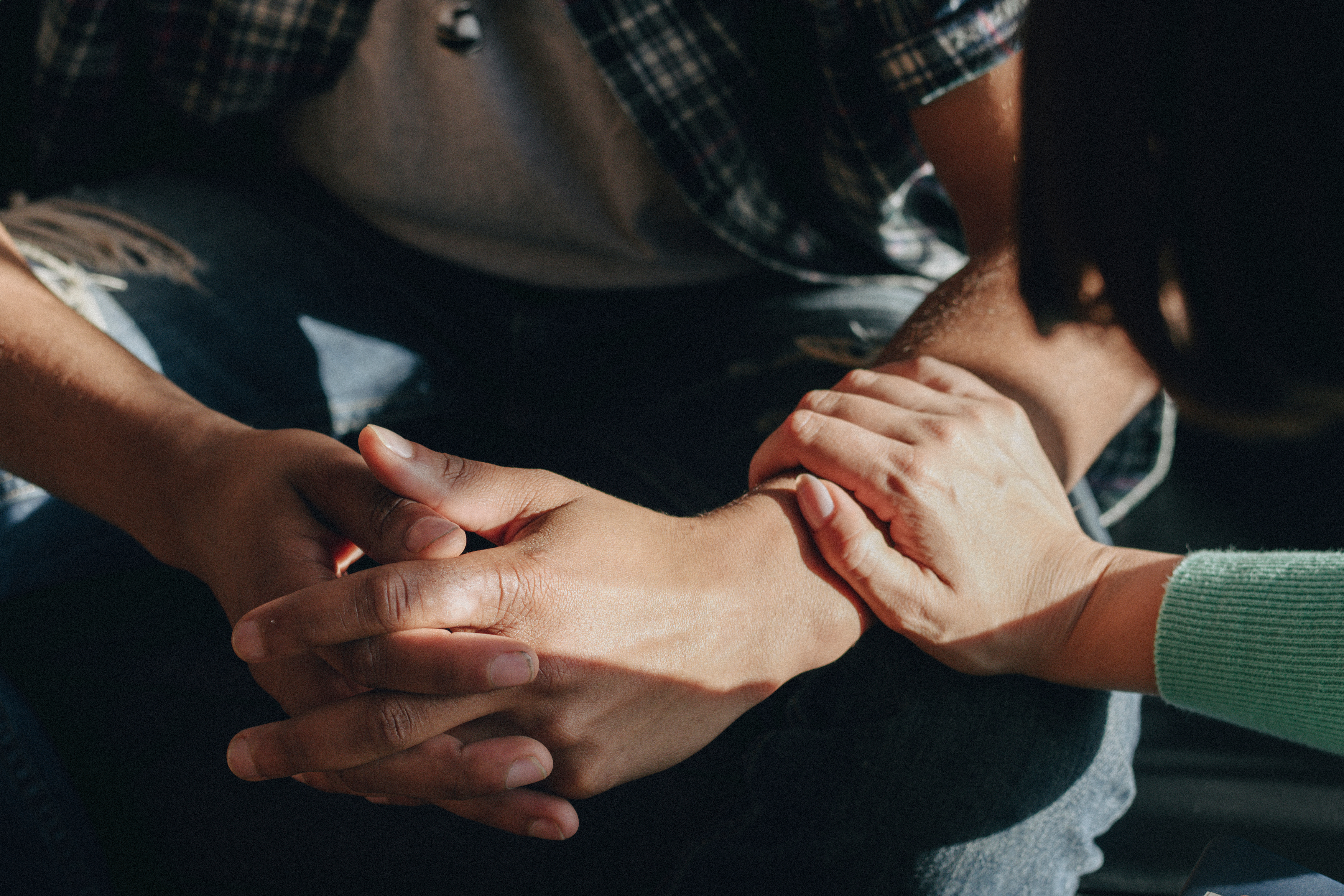 a woman's hands gentley placed on another person's arms
