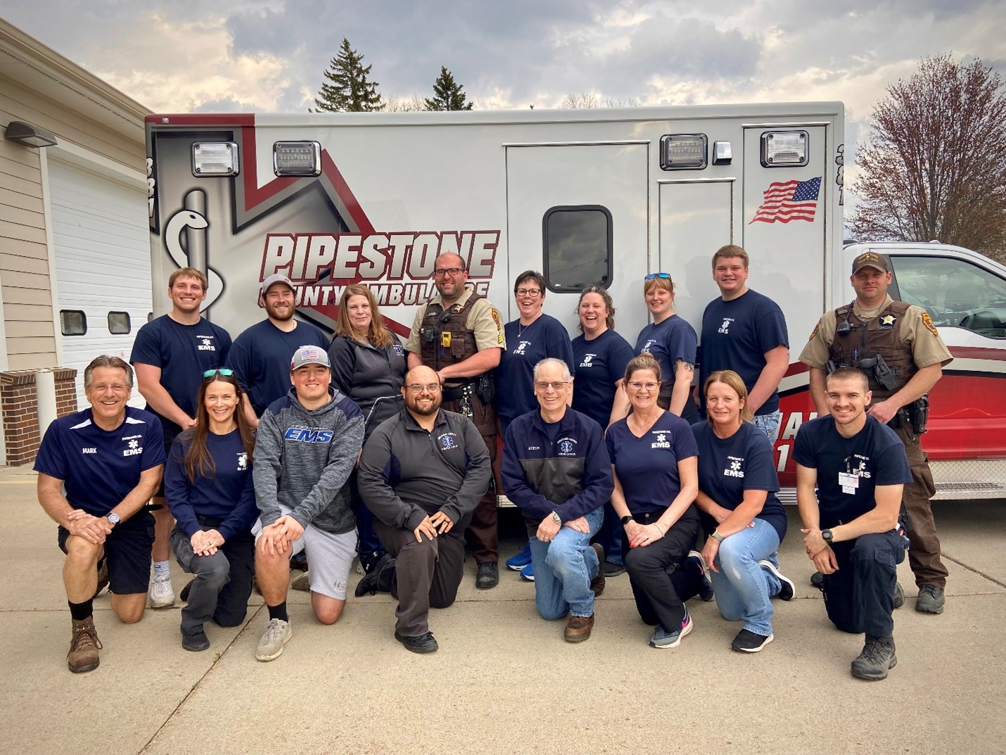 Pipestone Ambulance staff posing and smiling in front of ambulance