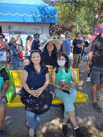 three cultural communications staff at a public outdoor event