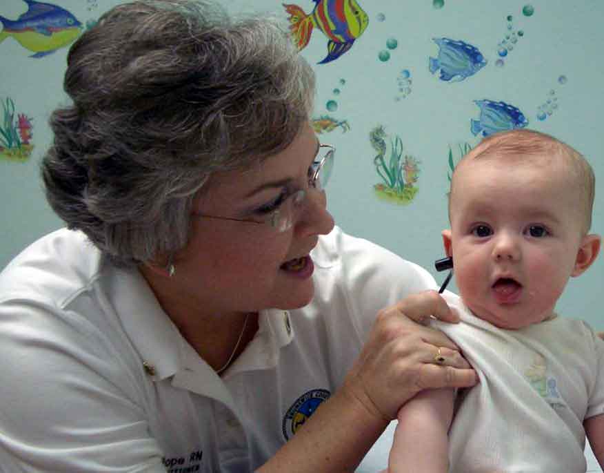 A provider performing a OAE test on an infant