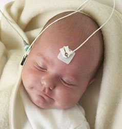 Infant having a newborn hearing screening test