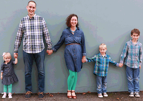 Family holding hands - little girl, dad, mom, little boy and older boy