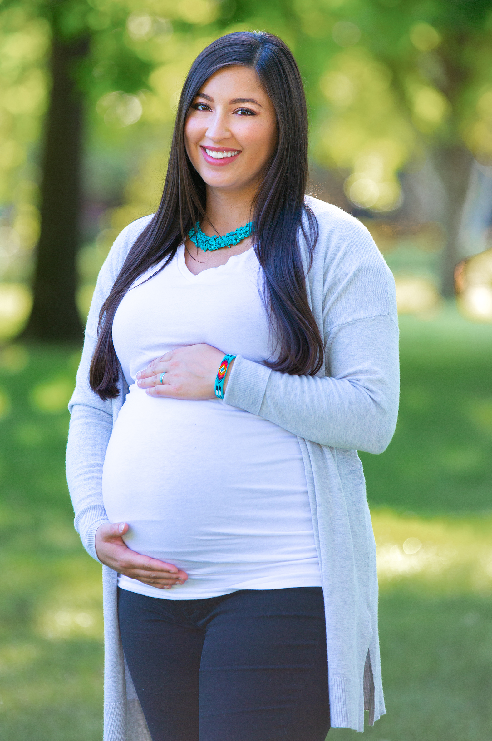 Pregnant Native American woman holding belly.