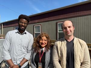 Three community health workers stand outside a clinic. 