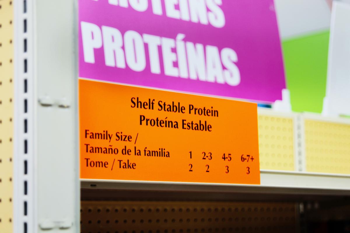 a shelf label reads "shelf stable proteins" in English and Spanish